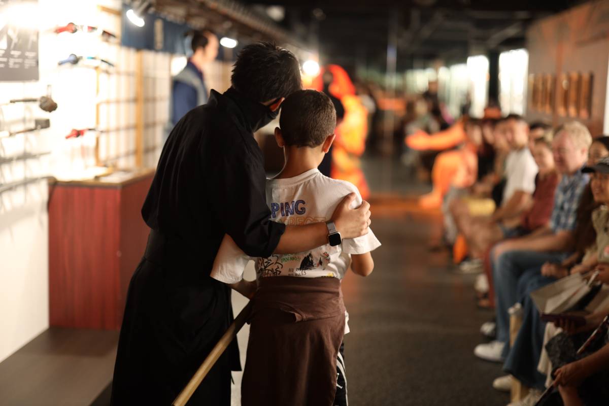 A ninja guide welcoming a young guest into the scene