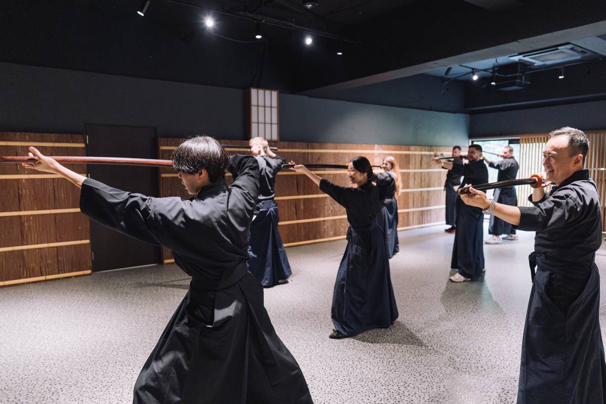 An instructor guiding a family through samurai kata practice