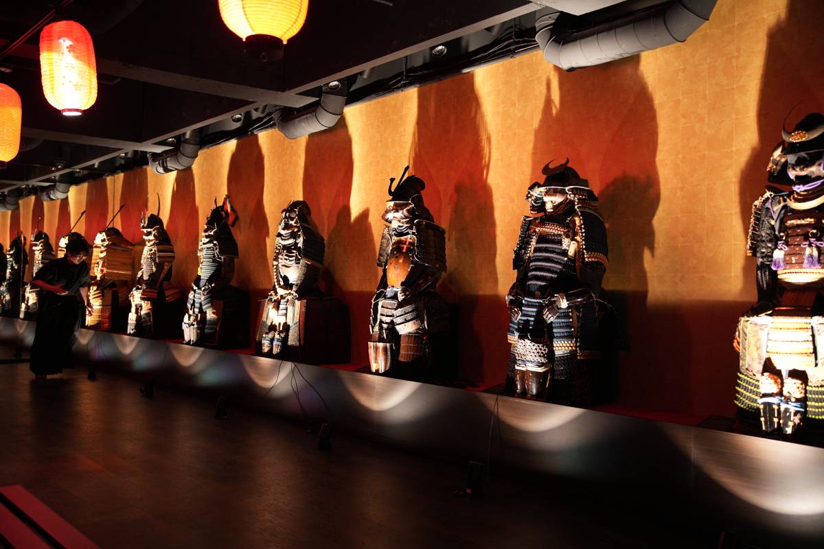 Rows of samurai armor under lantern light after dark