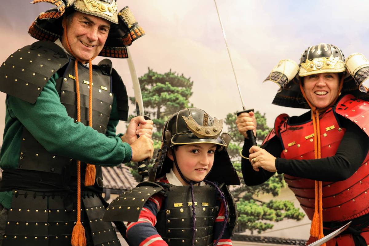 Child posing in soft samurai armor for a souvenir photo at the Samurai Ninja Museum Tokyo