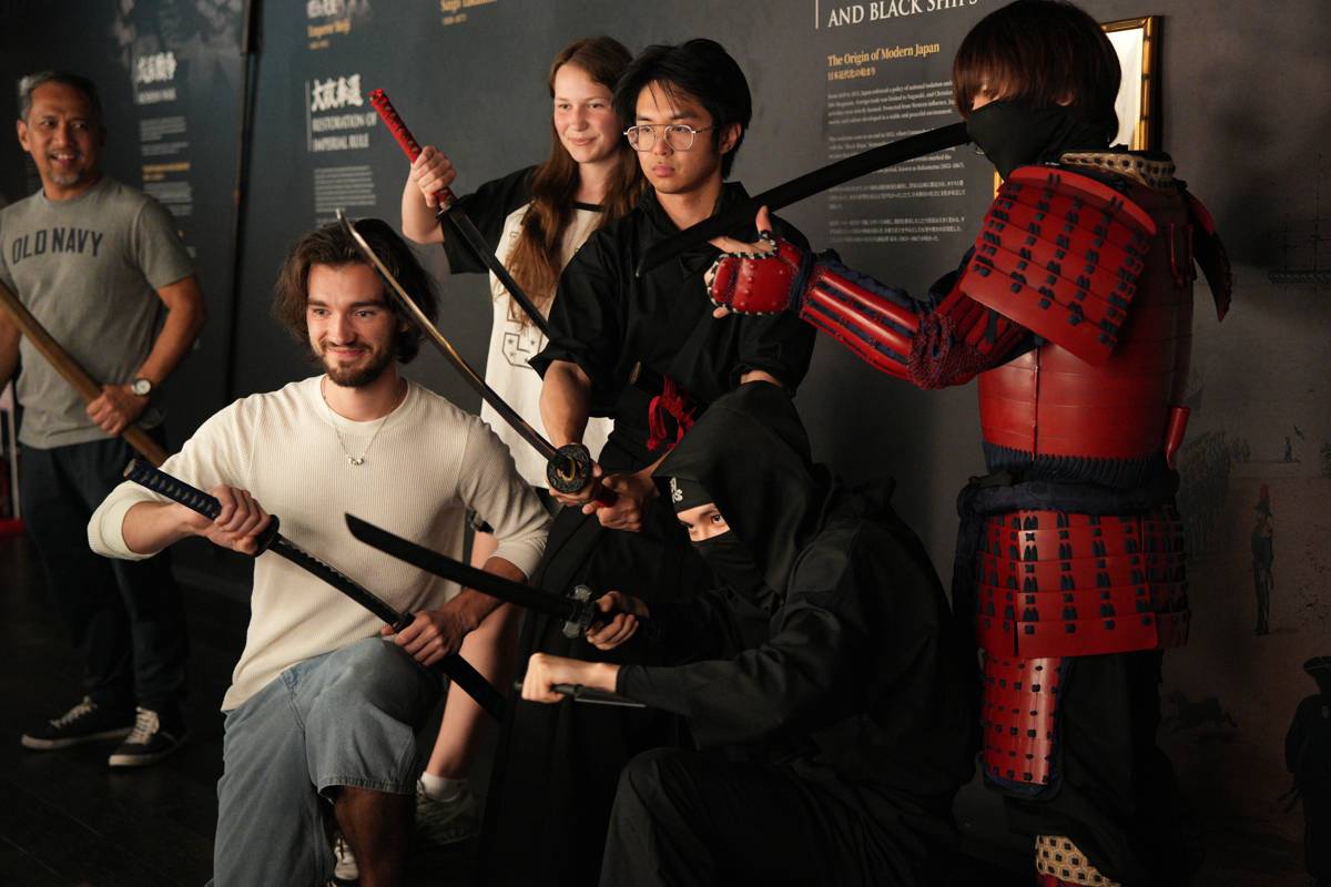 Guests striking poses with the cast, swords in hand